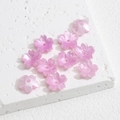 Nahaufnahme von rosa Kirschblütenperlen aus Harz mit Perlglanz für DIY-Schmuckherstellung - Rosa