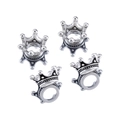 Detailed macro view of four vintage silver crown-shaped jewelry charms on white background - Antique Silver