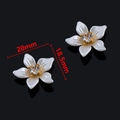 Vista macro de una pieza floral blanco perla con base dorada y cristal central transparente - Estilo Floral con Perlas Blancas Incrustadas / 20x18.5mm / Blanco