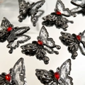 Macro detail of ink butterfly pendants with black metal frame and red crystal drop for DIY jewelry - Gunmetal