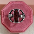 Gothic skull ring featuring red coffin design on a pink velvet jewelry display - US 7 / Red