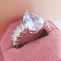 Pear-shaped teardrop zircon ring in a pink velvet box with side baguette stones - US 10 / White