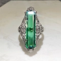Macro shot of rectangular emerald-cut green gemstone with vintage filigree silver band - US 6 / Green