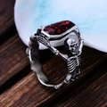 Gothic punk ring featuring silver skeletons holding a red coffin gem in vintage style - US 7 / Silver