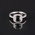 Luxury square black gemstone ring with halo diamonds on a reflective surface - Black
