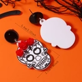 Dettaglio macro di orecchini gotici di Halloween con teschio e rose rosse su sfondo arancione - Bianco Nero K