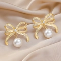 Elegant gold bow earrings with white pearl pendant on champagne satin background - Bowknot Pearl Gold