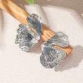 Detailed close-up of silver ginkgo leaf earrings with realistic vein texture on wood - Ginkgo Leaf Shape (WEH5030) / Silver
