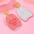 Detalle de pendientes de acrílico con purpurina en forma de corazón y texto de love - Estilo Colgante de Corazón Triple con Purpurina Roja (WEH5785)