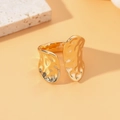 Golden open ring with irregular hammered lava texture on a minimalist stone display - Gold Hammered Irregular Style (M1592)