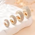 Lot de quatre boucles d'oreilles dorées en C serties de zircons blancs sur socle - Or Blanc