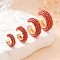Ensemble de quatre ear cuffs dorés en forme de C avec zircons rouges en tailles variées - Or Rouge