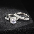 Detailed view of stacked shimmering halo ring set with round-cut center stone on black texture - US 5 / Silver