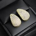Close-up of gold teardrop earrings with pavé-set zircons on a black leather jewelry box - Gold