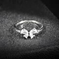 Gros plan d'une bague papillon en argent ornée de quatre pierres de zircone cubique étincelantes - US 5 / Argent