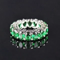 Sparkling silver ring with green oval cut emerald zircons on a reflective black background - US 5 / Green