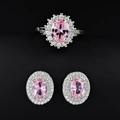 Detailed view of luxury pink oval gemstone ring and earrings set with halo diamond border - Pink / Size 5