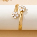 Détail du bracelet jonc doré ouvert orné de deux fleurs en émail blanc sur ruban plat - Bracelet blanc S4-3-06