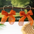 Dettaglio di orecchini a fiocco in chiffon arancione con anelli a cuore dorati - Stile Fiocco Arancione Cuore Oro (E1-1-19)