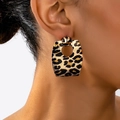 Close-up of geometric leopard print earrings with gold metal fasteners worn by a model - Trapezoidal Hollow Leopard Fastener Style (en-19-e045)
