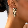Detail of model wearing triple heart leopard print dangle earrings with gold finish - Triple Heart Shape Leopard Style (en-19-e047)