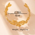 Detalle de brazalete dorado con diseño de flores y especificaciones de tamaño técnico - Dorado
