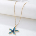 Detailopname van een blauwe zeester hanger met gouden rand aan een fijne ketting - Blauw