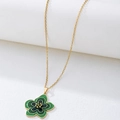 Détail du pendentif fleur en émail vert avec des bords de pétales dorés élégants - Vert
