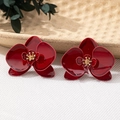 Macro view of dark red enamel orchid flower earrings with golden stamen detail - Wine Red Earrings