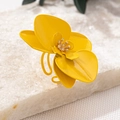 Makroaufnahme eines übergroßen gelben Orchideenrings mit mattem Finish auf weißem Stein - Gelber Ring