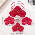 Makroaufnahme eines roten Orchideen-Schmucksets mit Armreif und passenden Accessoires - Set mit rosenroten Zirkonia