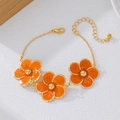 Elegant gold flower bracelet with orange enamel petals and delicate adjustable chain - Bracelet