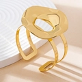 Detailed shot of a minimalist gold hollow geometric bangle on a textured surface - Bangle Only