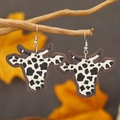 Cow head earrings with black and white cow print hanging on a natural wooden branch - Black and White Cow Print (WEH3922)