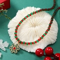 Detail van kerstkralenketting met rood-groene kralen en goudkleurige sneeuwvlok hanger - Sneeuwvlok Stijl (WXL1180)