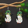Dettaglio di orecchini a forma di pinguino in legno per San Patrizio su un ramo - Pinguino