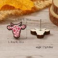 Macro detail of cow-shaped wooden stud earrings with pink spots and measurement specs - Rose Pink Cow Print (WEH4311)