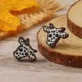 Detail shot of bull head stud earrings with black and white cow print on wood slice - Black and White Cow Print (WEH4311)