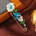 Detailansicht der Vintage-Blumenbrosche mit blauen Strasssteinen und Emaille-Blüten - Seeblaues Blumen Pin