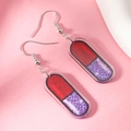 Detail of quirky pink acrylic capsule earrings with purple glitter and silver hooks - Red Purple Glitter Capsule Style (WEH4633) / Red
