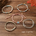Detail of 5-piece Bohemian beaded bracelet set with Evil Eye and Hamsa Hand charms - White