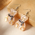 Close-up of cute pink resin bear earrings with leopard bow ties on a neutral background - Beige Bear with Leopard Scarf (WEH4719)