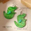 Macro view of green acrylic crocodile earrings showing 6.5cm length and golden details - Green Crocodile (WEH4717)