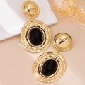 Detail of vintage bohemian drop earrings with hammered gold texture and black oval stone - Black