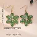 Detalle de pendientes de flor esmaltada verde con centro de estrella dorada - Verde Oscuro