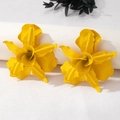 Macro shot showing matte yellow orchid flower earrings on a white display stand - Lemon Yellow