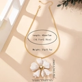 Détail d'un pendentif fleur rétro en émail avec perle sur une chaîne dorée - Milky blanc