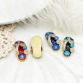 Detailed macro view of evil eye slipper charms with colorful enamel and zircon accents - Red Evil Eye Slipper