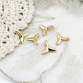 Detailed macro view of five 18K gold plated whale tail charms with polished mirror finish - Fish Tail