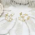 Detail of 18k gold plated sun cross charms for DIY jewelry making on lace background - Simple Left Cross